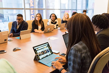 Team collaboration in a tech-driven office, focused on innovation. HD wallpaper