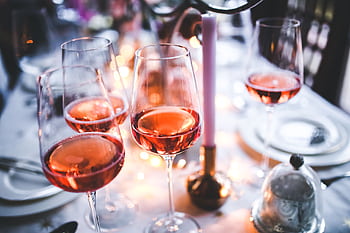 A chic table setting with rose wine glasses, perfect for a sophisticated evening gathering. HD wallpaper