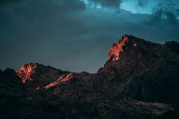 A breathtaking view of red-tinted mountainous peaks in Nevada under dramatic twilight skies. HD wallpaper