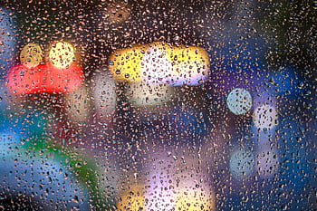 Raindrops on a window with vibrant city lights bokeh in Tân Bình, Vietnam. HD wallpaper