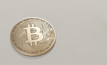 A detailed of a Bitcoin cryptocurrency coin with a neutral background, symbolizing digital finance and currency. HD wallpaper