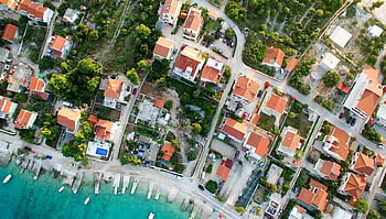 A scenic aerial shot of a seaside town in Croatia featuring rooftops and clear blue waters. HD wallpaper