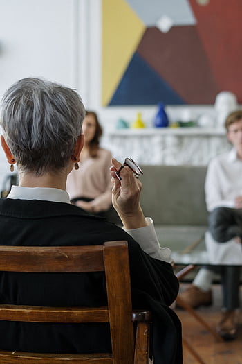 A therapist leads a couple's therapy session in a modern office setting. HD phone wallpaper