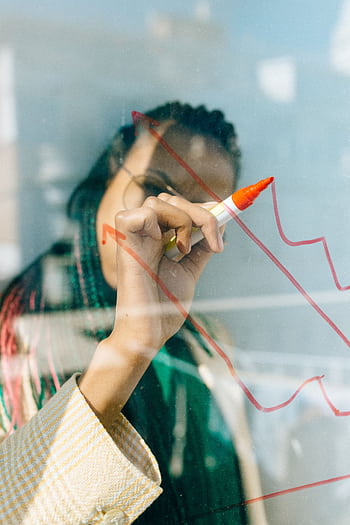 A businesswoman draws a red financial graph on a glass panel, symbolizing strategy and success. HD phone wallpaper