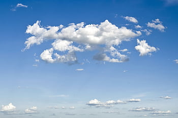 A peaceful blue sky filled with fluffy cumulus clouds creating a tranquil atmosphere. HD wallpaper