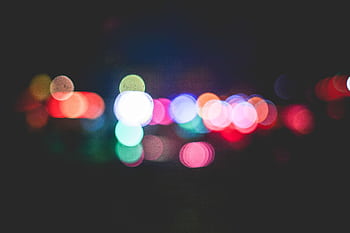 Blurred bokeh lights in various colors create a vibrant nighttime scene. HD wallpaper