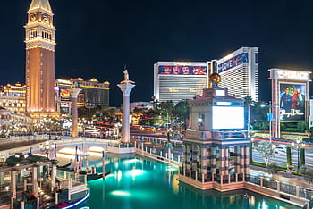 A stunning night view of Las Vegas Strip featuring illuminated landmarks and vibrant reflections. HD wallpaper