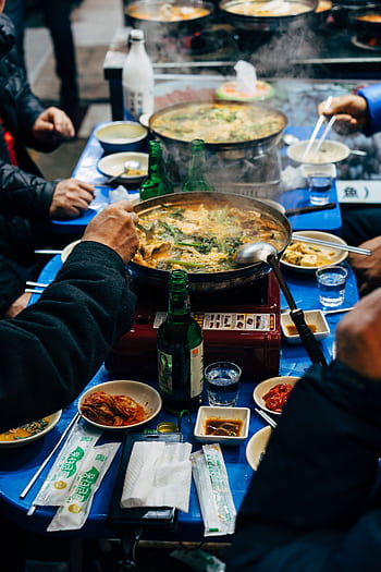 A vibrant dining table with Korean dishes and drinks, capturing authentic Seoul street food culture. HD phone wallpaper