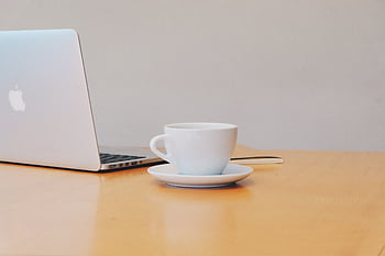 A clean and modern workspace featuring a laptop and a white coffee cup on a wooden desk. HD wallpaper