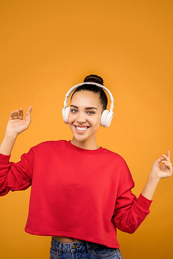 Smiling woman in red sweater and heads posing against an orange background. HD phone wallpaper