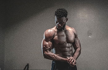 A strong, shirtless male bodybuilder showcasing muscles and strength in a gym setting. HD wallpaper