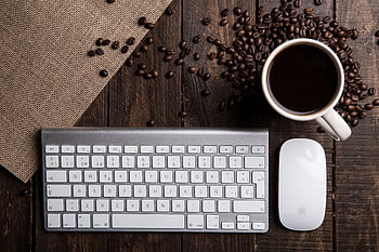 Top view of a coffee cup with keyboard and mouse on a rustic wooden desk. HD wallpaper
