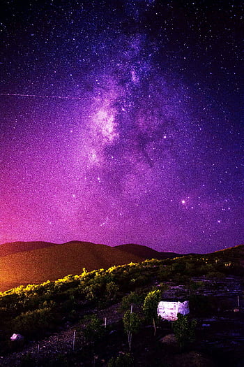 A stunning view of the Milky Way galaxy over a tranquil landscape, perfect for night sky enthusiasts. HD phone wallpaper