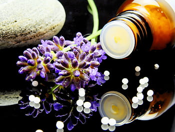 Lavender flowers with herbal homeopathy on a reflective surface, ideal for natural therapy themes. HD wallpaper