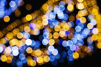 Vibrant blue and gold bokeh lights create a stunning abstract pattern on a black background. HD wallpaper