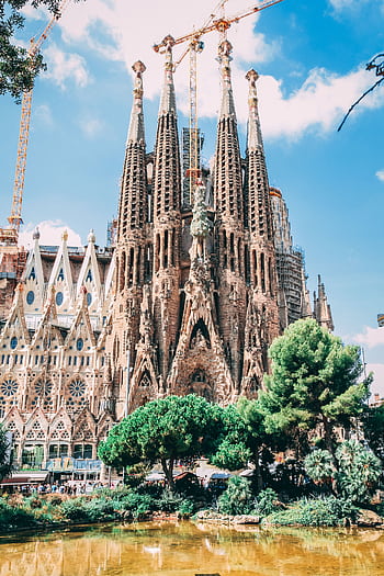 Iconic view of Sagrada Familia in Barcelona with clear blue skies, showcasing Gothic architecture. HD phone wallpaper