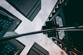 Dynamic low angle view of futuristic skyscrapers in a modern cityscape. HD wallpaper