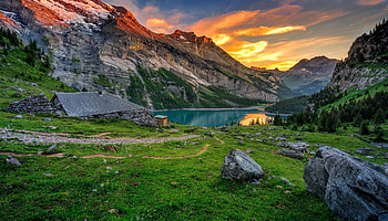 Landscape with mountain and lake, hills, house, meadow, beautiful, grass, rocks, serenity, tranquil, mountain, lake, summer, reflection, hut, sky, sunset HD wallpaper