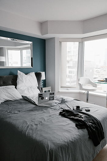 Comfortable bedroom in Toronto with a city view, featuring a laptop and modern decor. HD phone wallpaper