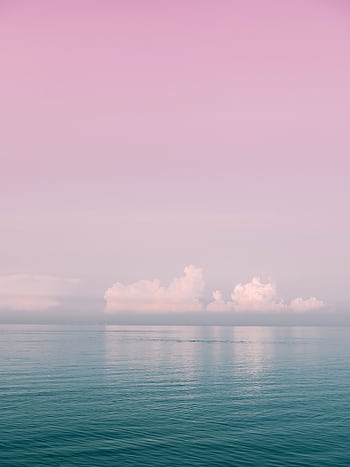 Serene ocean view with pink sky and soft clouds at sunset, perfect for calm and peaceful moods. HD phone wallpaper
