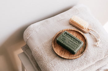 A calming spa scene featuring eco-friendly soap and neatly folded towels, evoking relaxation. HD wallpaper