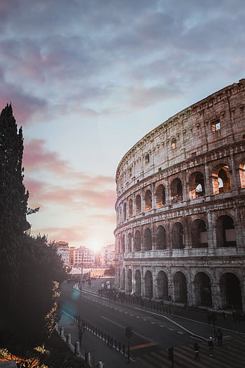 Scenic view of the iconic Colosseum in Rome at sunset, showcasing ancient architecture. HD phone wallpaper