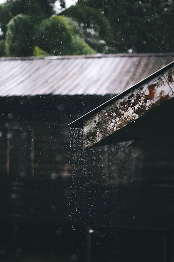 Glistening rain falls from a rusty metal roof, creating a moody, atmospheric scene. HD phone wallpaper