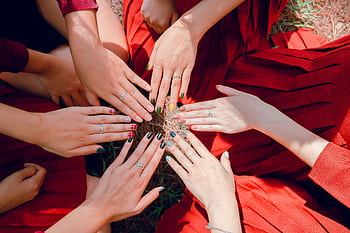 A vibrant top view of women showcasing painted nails and rings, emphasizing friendship and togetherness. HD wallpaper