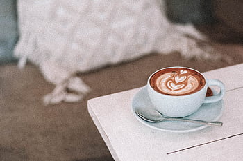 Latte with beautiful art in cozy café setting, perfect for morning relaxation. HD wallpaper