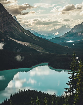 Stunning view of a tranquil lake surrounded by towering mountains in the Canadian Rockies. HD phone wallpaper