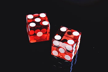 Close-up of two red dice on black surface, symbolizing chance and luck. HD wallpaper