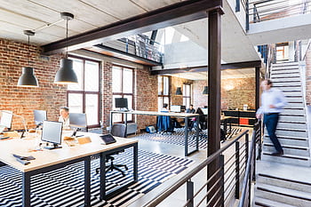 Spacious and stylish open-plan office with loft and industrial aesthetic. HD wallpaper