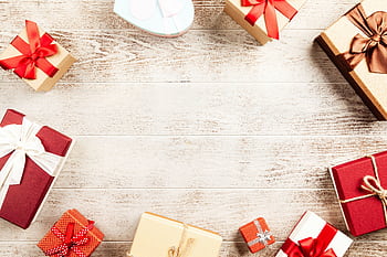 A collection of beautifully wrapped gift boxes with ribbons on a wooden table, perfect for holiday themes. HD wallpaper
