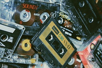 An assortment of vintage cassette tapes from the 80s and 90s, showcasing retro design and nostalgic appeal. HD wallpaper