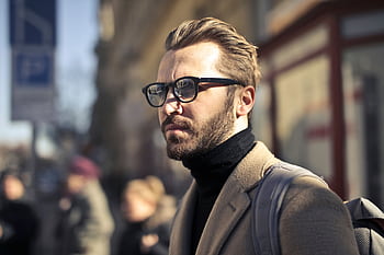 A fashionable man with glasses walks through the vibrant streets of Budapest, Hungary. HD wallpaper