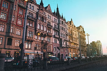 Historic Prague street with classic architecture bathed in sunset glow, highlighting its urban charm. HD wallpaper