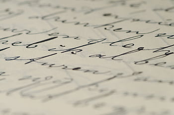 Close-up of elegant handwritten calligraphy on paper showcasing fine ink script. HD wallpaper