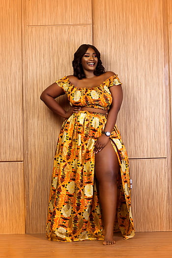 Confident African woman posing elegantly in a vibrant yellow dress, embodying style and grace. HD phone wallpaper