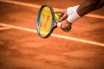 Close-up of a tennis player preparing to serve on a clay court in Montevideo. HD wallpaper