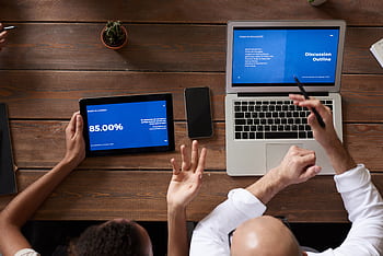 Overhead view of professionals collaborating on digital devices during a meeting at the office. HD wallpaper
