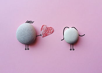 Charming stone art with heart symbol on pink background, symbolizing love and connection. HD wallpaper