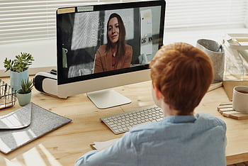 A child participating in an online class at home, focused on the educational content displayed on a computer. HD wallpaper