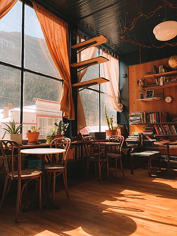 Warm, sunlit café in Silver Plume, Colorado with wooden furniture and bookshelves. HD phone wallpaper