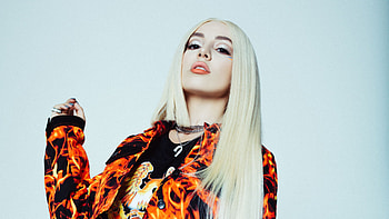 White Hair Ava Max Is Wearing Orange Black Dress Standing In Light Blue Background Girls HD wallpaper