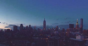 Captivating view of the New York City skyline at dusk featuring the iconic Empire State Building. HD wallpaper