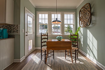Bright dining area with wooden furniture and large windows showcasing natural light. HD wallpaper