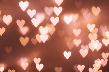 Soft focus heart-shaped bokeh lights creating a romantic atmosphere. HD wallpaper