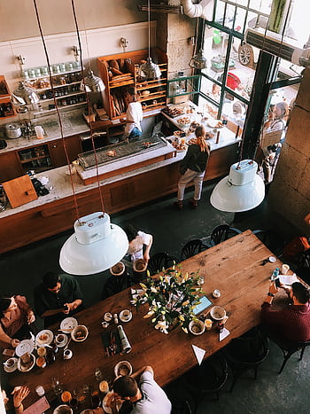 A vibrant aerial view of a busy cafe in Kraków, showcasing patrons enjoying baked goods and coffee. HD phone wallpaper