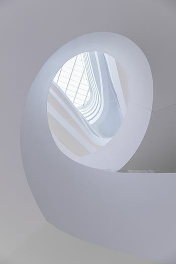 A stunning low-angle view of a modern spiral staircase with natural light in Melbourne. HD phone wallpaper