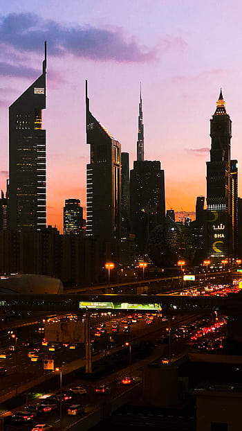 A captivating view of Dubai's skyline with skyscrapers during sunset. HD phone wallpaper